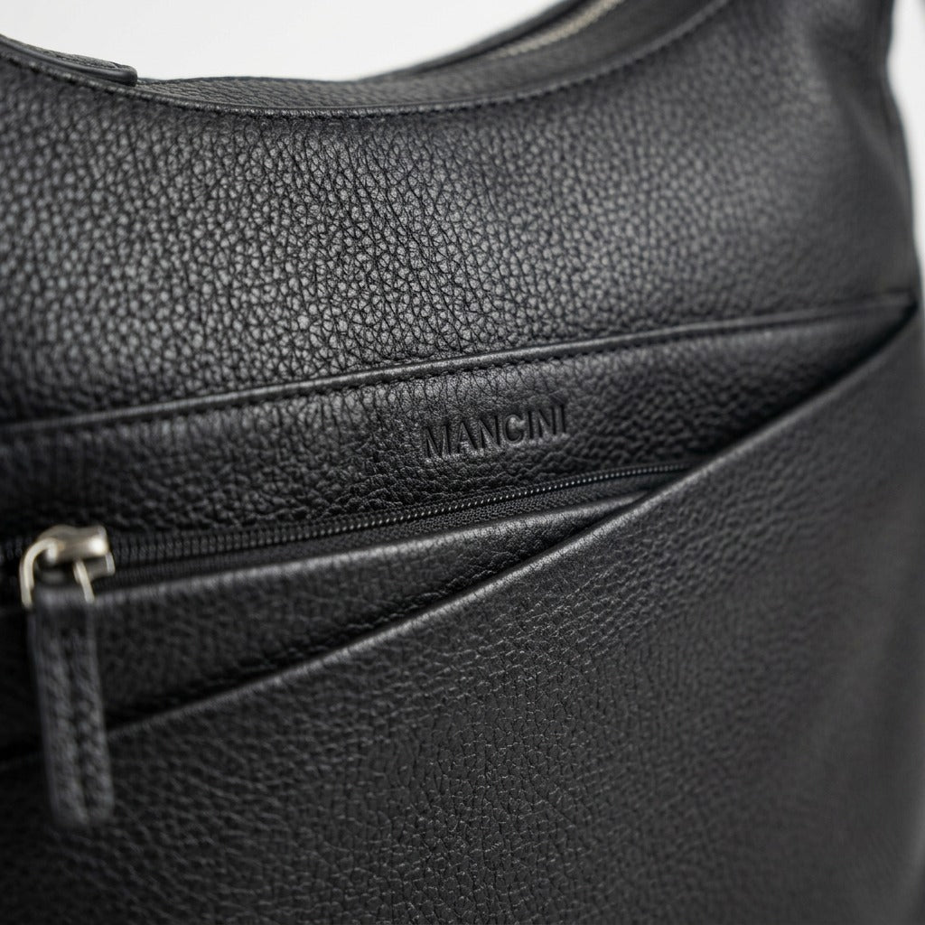 Macro close-up photograph of the textured black leather and subtle embossed label.
