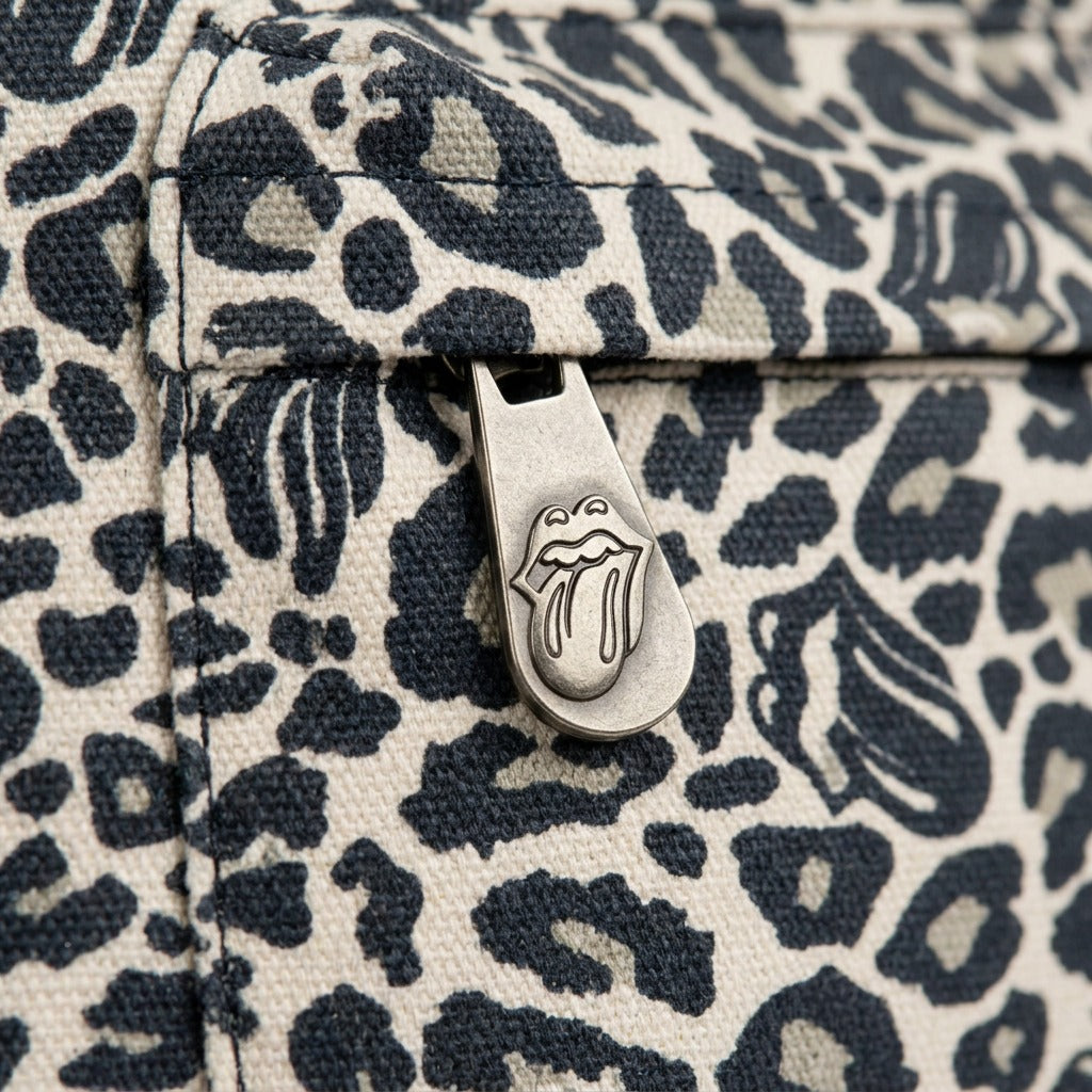 A macro photograph showing the unique tongue-logo patterned canvas and a precision branded zipper pull on the Bugatti Rolling Stones backpack.