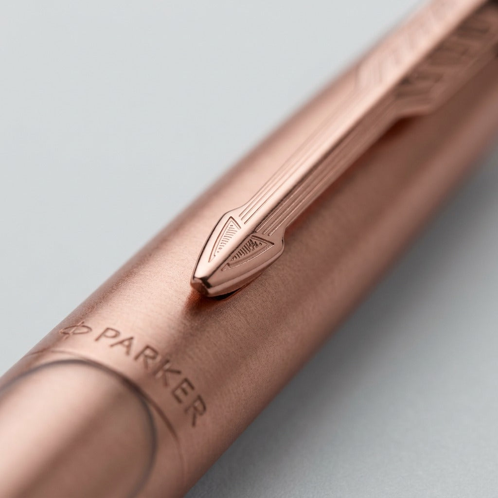 Macro detail of Parker Jotter XL pen in matte rose gold showing arrow clip and engraved logo.