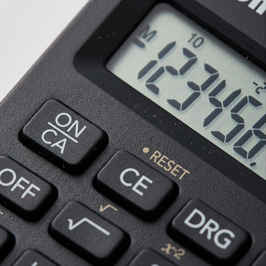Macro detail of the Canon F-605G calculator showing digital display characters and keypad texture.